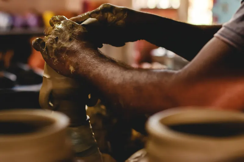 Mains d'un artisan fa&ccedil;onnant de la poterie sur un tour traditionnel